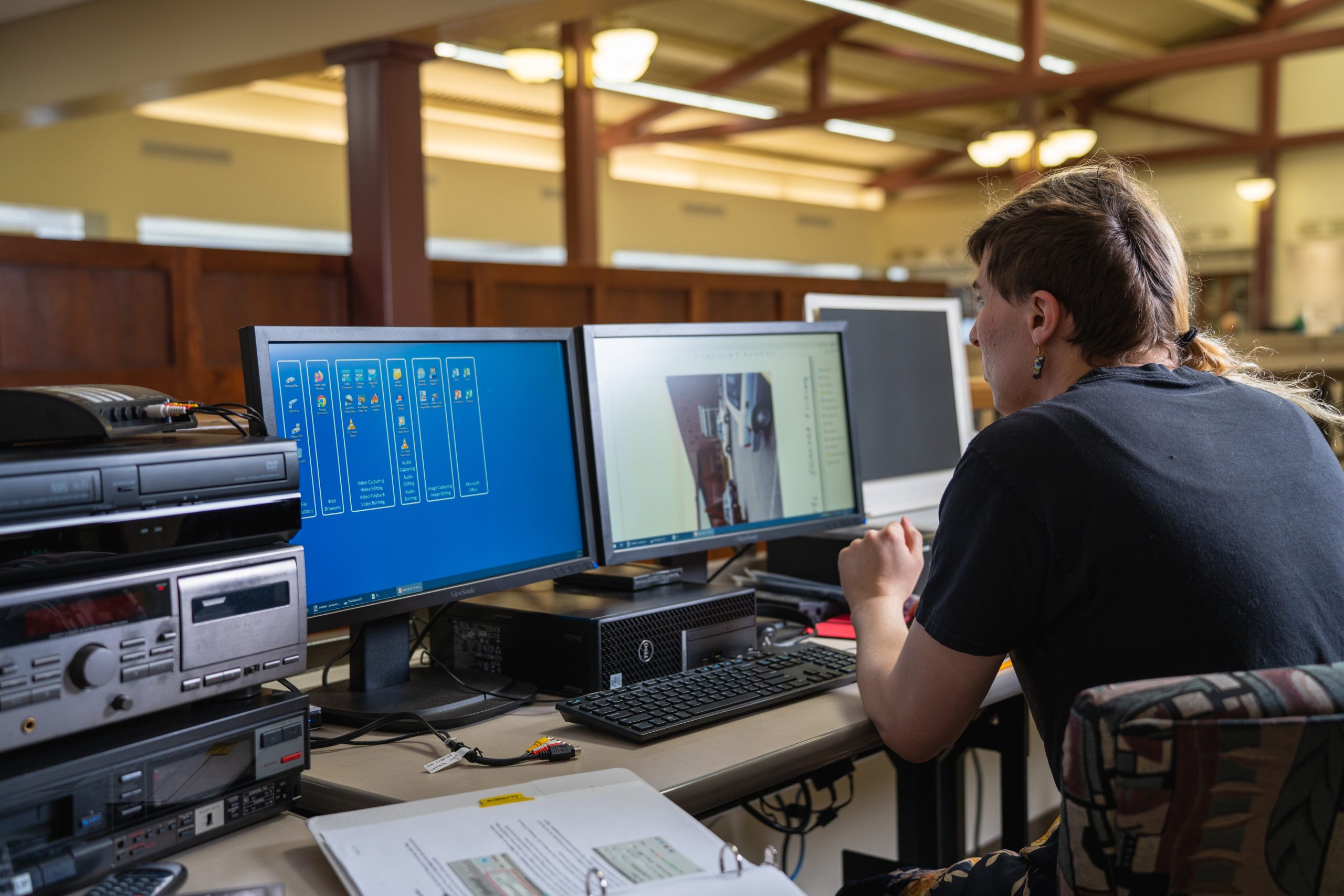 Individual looking at two computer screens